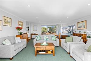 a living room with two couches and a coffee table at Oceanview on Broadway in Waihi Beach