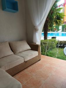 um sofá num quarto com vista para a piscina em APARTMENT STUDIO DELUXE MARINA CAPE 4 stars resort 33 5 em Aheloy