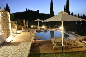a swimming pool with an umbrella and chairs next to a pool at Corfu View Deluxe in Perama