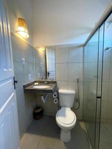 a bathroom with a toilet and a sink at Pousada Vila Nativa in Arraial d'Ajuda