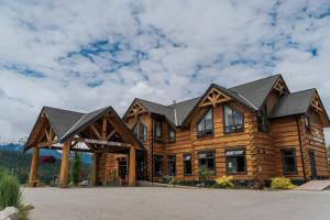 a large log house with a gambrel roof at Basecamp Lodge Golden in Golden