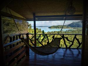 a hammock on a porch with a view of a lake at The Overlook in San Vicente