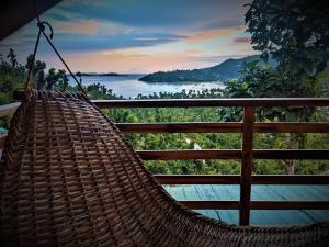 a rattan hammock hanging on a balcony overlooking a lake at The Overlook in San Vicente