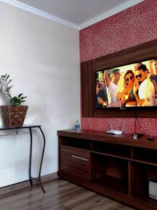 a living room with a flat screen tv on a wall at Apartamento prático, simples CDHU. in Itatiba