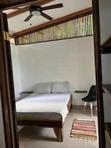 a bedroom with a bed with a ceiling fan and a rug at Comfy jungle place / FiberOptic/1 km from the beach in Cocles