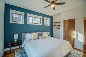 1 dormitorio con 1 cama grande y pared azul en Harmony Cove Lakehouse: 3 Bed/3 Bath, en Eclectic