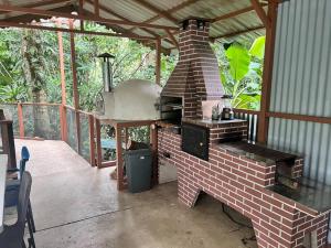 a brick oven on a patio with a wooden roof at Comfy jungle place / FiberOptic/1 km from the beach in Cocles
