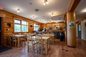 un restaurante con paredes de madera, mesas y sillas en Basecamp Lodge Golden, en Golden