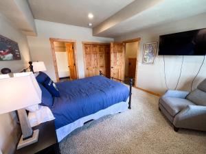 een slaapkamer met een bed, een bank en een tv bij Grand View Lodge in Whitefish