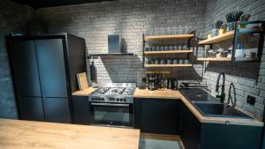 Una cocina con estufa y refrigerador negro. en Willa Perła Jezior, en Mrągowo