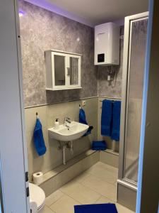 een badkamer met een wastafel, een toilet en blauwe handdoeken bij Pension King Royal in Hamburg