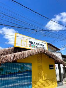 a yellow building with a sign on top of it at Pousada Vila Nativa in Arraial d'Ajuda