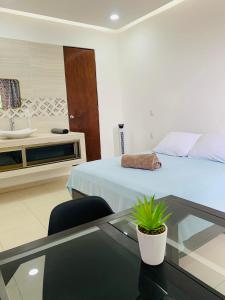 een slaapkamer met een bed, een tafel en een wastafel bij Alojamiento tres pinos in Yelateni