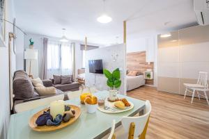 a kitchen and living room with a table with food on it at CARTAGENAFLATS, Apartamentos Anfiteatro Romano in Cartagena