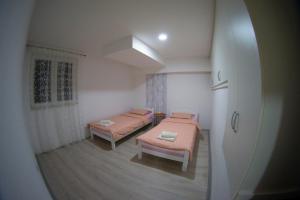 a small room with two beds and a window at UKROPINA APARTMENTS in Trebinje