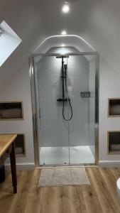 a shower with a glass door in a bathroom at The Old Workshop - a cosy country retreat in Gloucester +22 photos