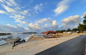 uma praia com barcos e um gazebo na água em Getaway Mobile Home em Drage