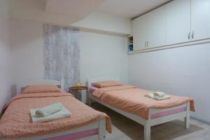 two beds in a room with white cabinets at UKROPINA APARTMENTS in Trebinje