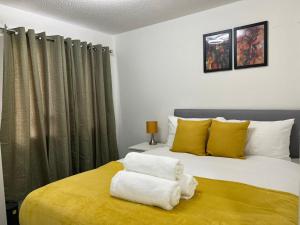 a bedroom with a bed with yellow and white pillows at Perculiar Homes in Birmingham