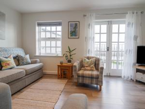 een woonkamer met een bank en een stoel bij Harbour View in Porthmadog