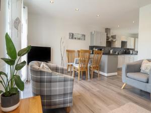 a living room with a couch and chairs and a kitchen at Harbour View in Porthmadog
