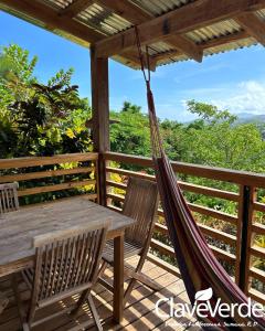 - un hamac sur une terrasse avec une table et des chaises dans l'établissement Clave Verde Ecolodge, à Las Terrenas