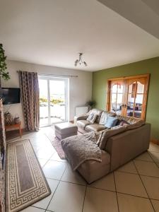ein Wohnzimmer mit einem Sofa und einem TV in der Unterkunft Causeway Coast Country Cottage, Pet-friendly in Ballycastle