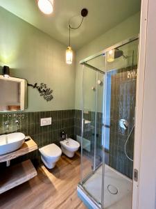 a bathroom with a shower and a toilet and a sink at UNODUE House in Cuneo