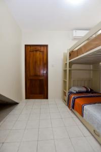 薩利納斯的住宿－Hostal Judy Suites，带两张双层床和一扇门的房间