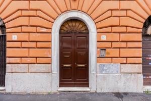ローマにあるDiecipassi dal Colosseoの茶色の扉のあるオレンジレンガ造り