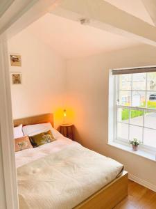 um quarto com uma cama e uma janela em Large historic family home nr Longleat and Bath em Warminster