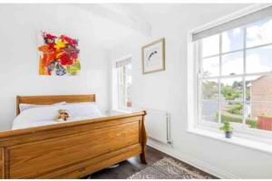 a bedroom with a wooden bed and a window at Large historic family home nr Longleat and Bath in Warminster +39 photos