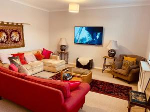 沃明斯特的住宿－Large historic family home nr Longleat and Bath，客厅配有红色的沙发和椅子