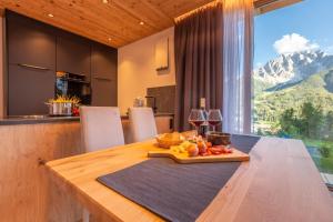 a kitchen with a table with a plate of fruit on it at Chalet Panorama Himmelreich in San Candido