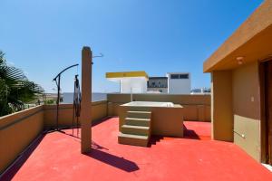 - un balcon avec une table et des escaliers sur le toit dans l'établissement Hostal Judy Suites, à Salinas