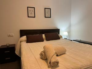 a bedroom with a bed with a towel on it at APARTAMENTO ROMELIA bajo A in Tivenys