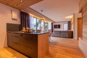 an open kitchen and living room with a kitchen island at Chalet Panorama Himmelreich in San Candido +15 photos
