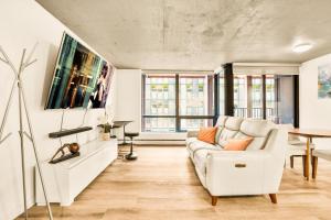 溫哥華的住宿－Urban Chic: Sleek 2BR in Heart of Vancouver，客厅配有白色的沙发和桌子