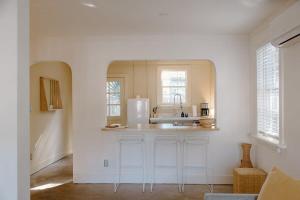 a white kitchen with a sink and a counter at The Bungalow Lounge by WB Abodes in Wrightsville Beach