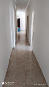 un largo pasillo con paredes blancas y suelo en Luxry flat in matrouh, en Marsa Matruh