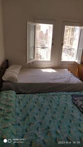 łóżko w pokoju z oknem i pościelą w obiekcie Luxry flat in matrouh w mieście Marsa Matruh