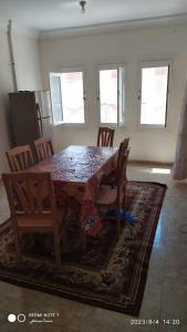 a dining room table with chairs and a table and a kitchen at Luxry flat in matrouh in Marsa Matruh