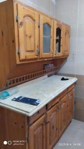 a kitchen with wooden cabinets and a counter top at Luxry flat in matrouh in Marsa Matruh