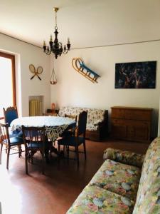 un soggiorno con tavolo, sedie e divano di I Due Cervi a Portico di Romagna