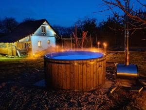 a large wooden tub in a yard at night at Domek SADKOWO - wśród jabłoni , balia ogrodowa dodatkowo płatna in Pollnow