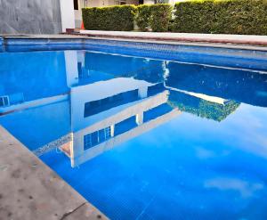 una piscina de agua azul con una escalera dentro en LaVid Aguascalientes en Aguascalientes