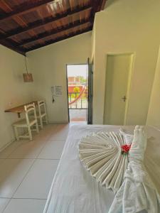 a bedroom with a white bed with a dress on it at Pousada Paradise in Coruripe