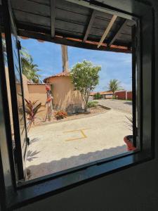 una ventana con vistas a la calle desde un edificio en Pousada Paradise en Coruripe