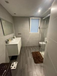 La salle de bains blanche est pourvue d'un lavabo et d'une douche. dans l'établissement Increíble piso céntrico, à Gandía