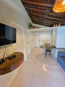 a living room with a large television and a table at Pousada Paradise in Coruripe
